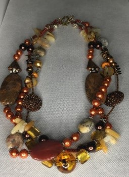 Tripple stranded burnt orange peral bead beaded necklace with multiple gemstones.