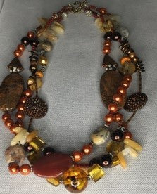 Tripple stranded burnt orange peral bead beaded necklace with multiple gemstones.